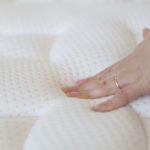 mattress qualify, hand on mattress